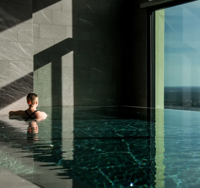 Person i en infinitypool med utsikt