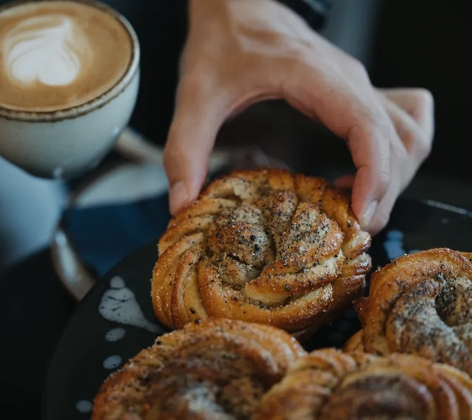 En hand plockar en kardemumma bulle.