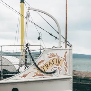 En vit båt som ligger på toppen av ett vattendrag.