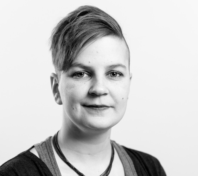 A black and white picture with a smiling woman in short hair.