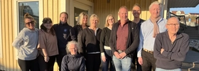 En grupp människor, styrelsen Destination Skaftö, står framför Solrosen i Krögen.
