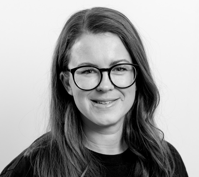 A black and white photo of a woman wearing glasses.