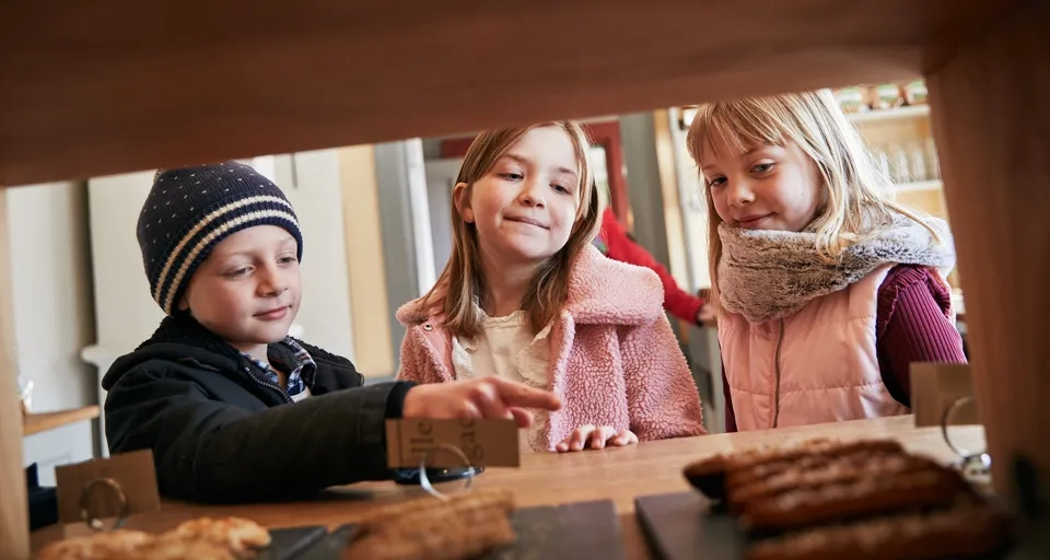 En grupp små barn som står runt ett bord.