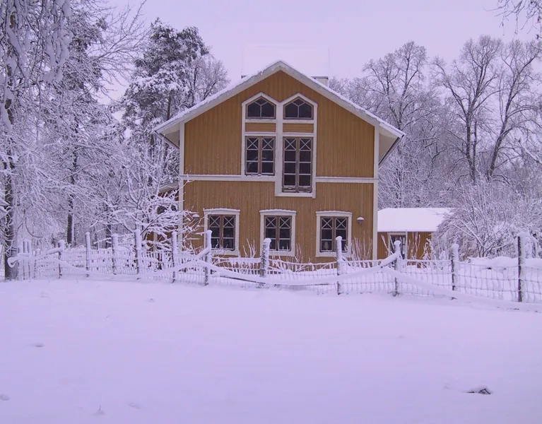 A house in the middle of a snowy field.