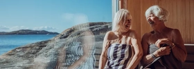 A couple of people that are sitting by a window.