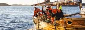 A group of people on a boat in the water.