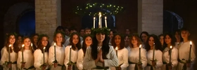 A group of women standing next to each other holding candles.
