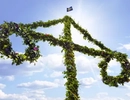 En midsommarstång med  blommor en solig dag.