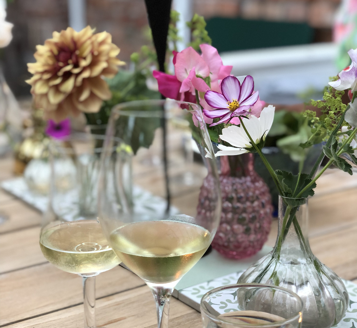 Ett träbord med vinglas och en vas fylld med blommor på.