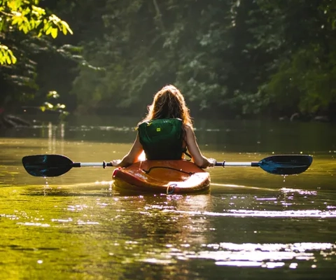 Flicka som paddlar kanot.