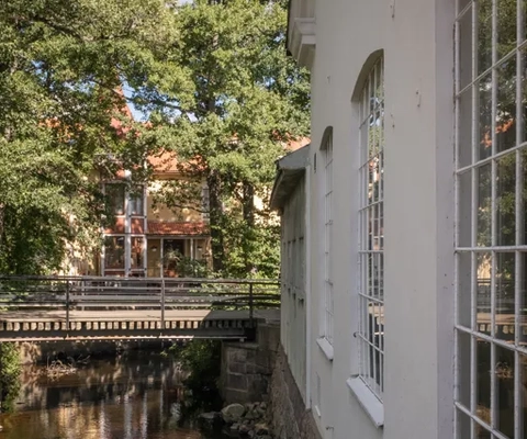 Vy på museets fasad samt en bro över Tidan