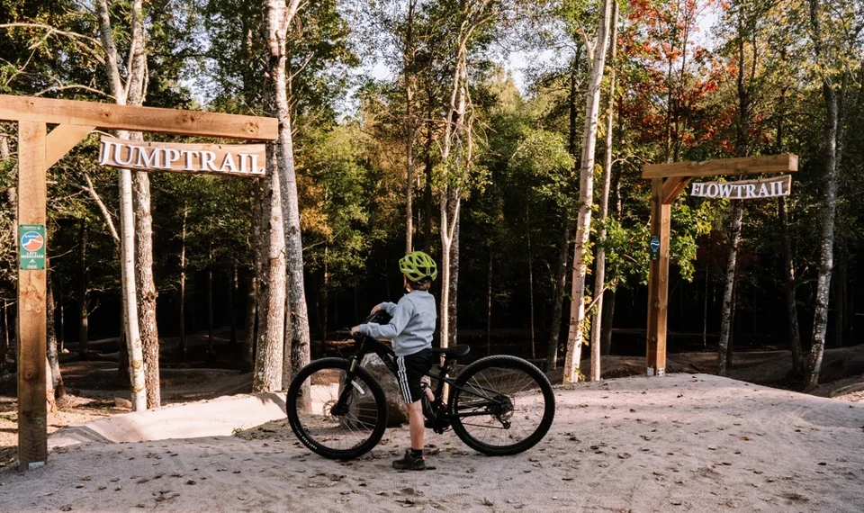 Eine Person auf einem Fahrrad vor einem Schild.