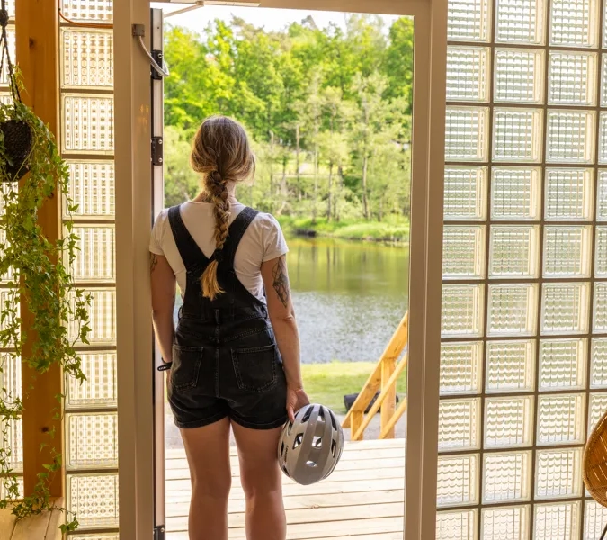 A woman standing in front of a glass door.