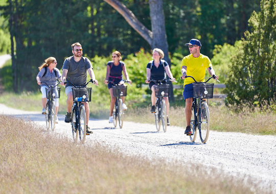 En grupp människor som cyklar på en grusväg.