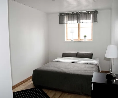 Ett sovrum med en säng och ett fönster.