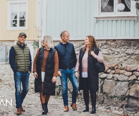 En grupp människor som går längs en kullerstensgata.