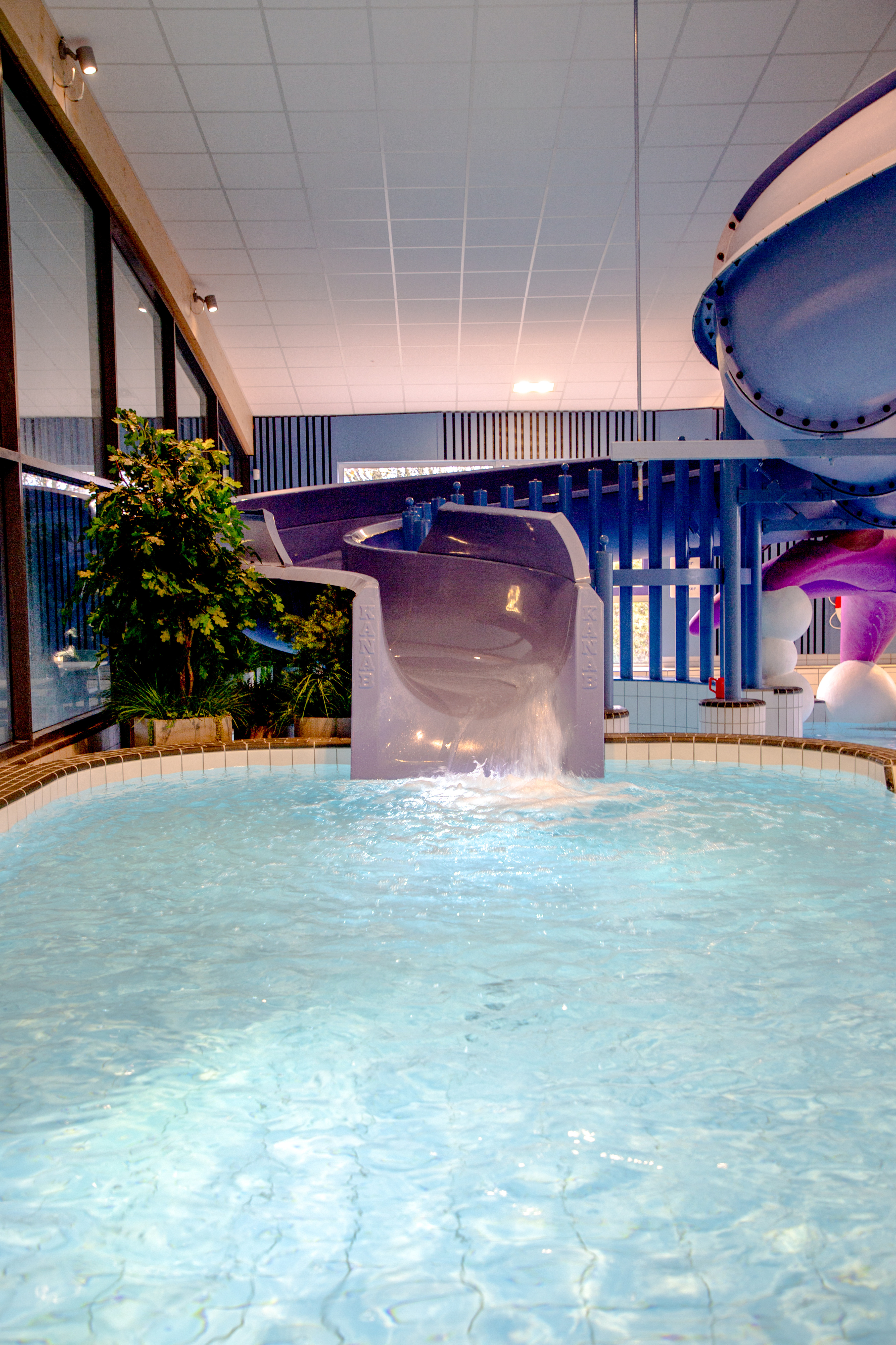 En stor inomhuspool med rutschkana.