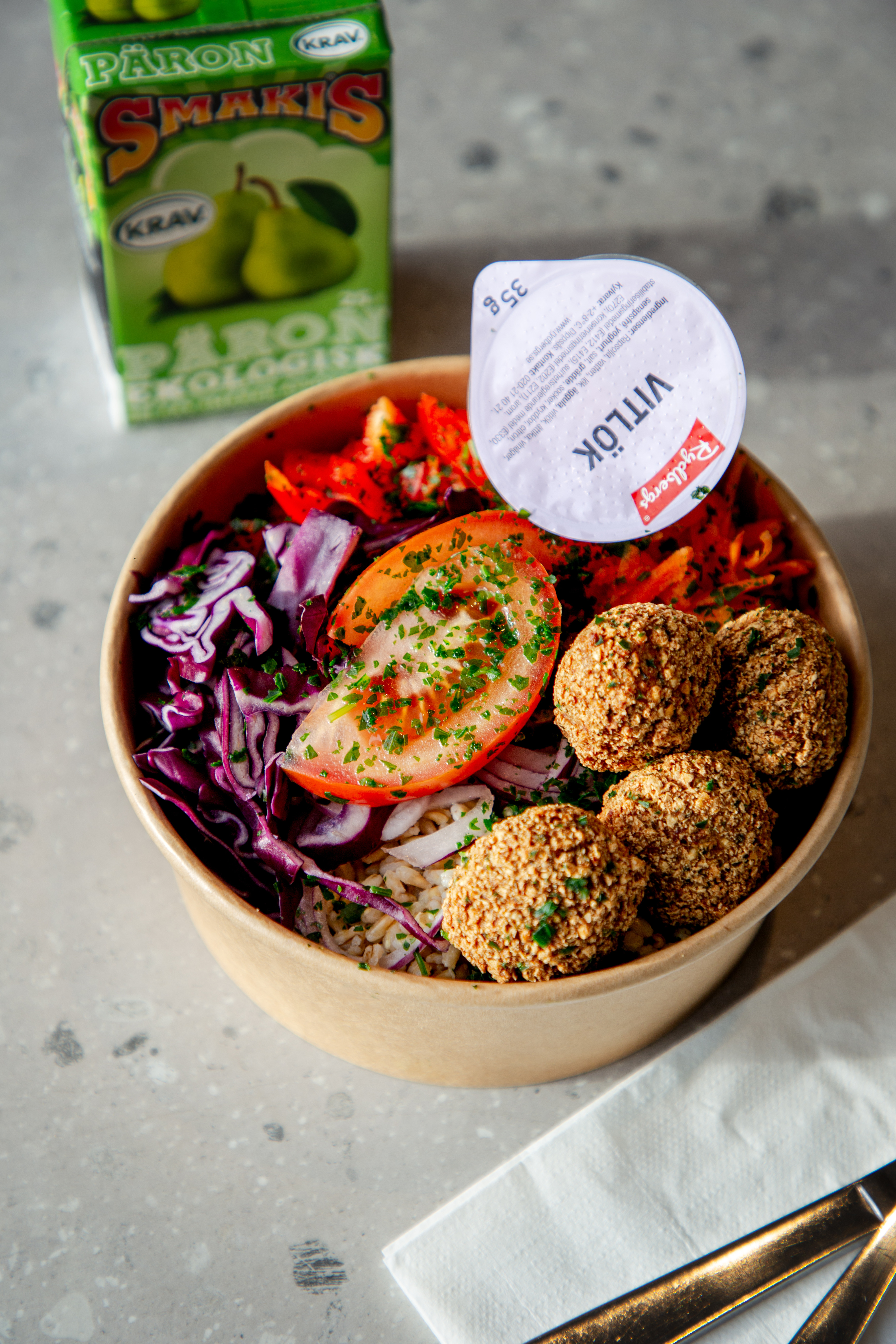 En skål fylld med falafel och grönsaker.