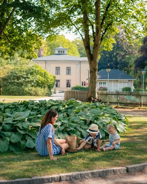 Eine Frau und ein Kind sitzen im Gras.