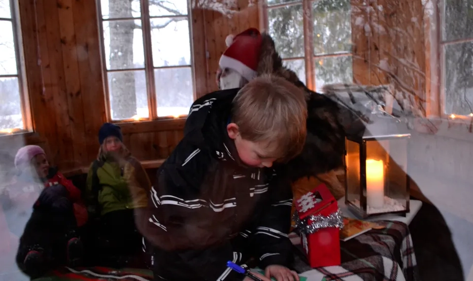 Ett barn skriver önskelista till tomten.