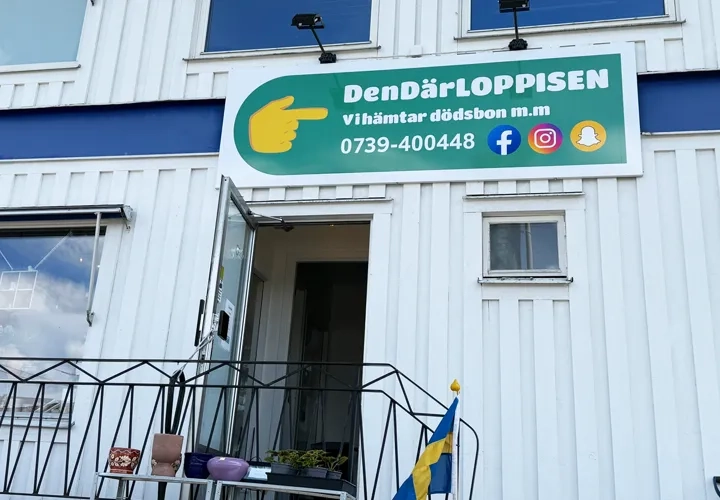 En vit byggnad med en skylt för en loppis i Henån