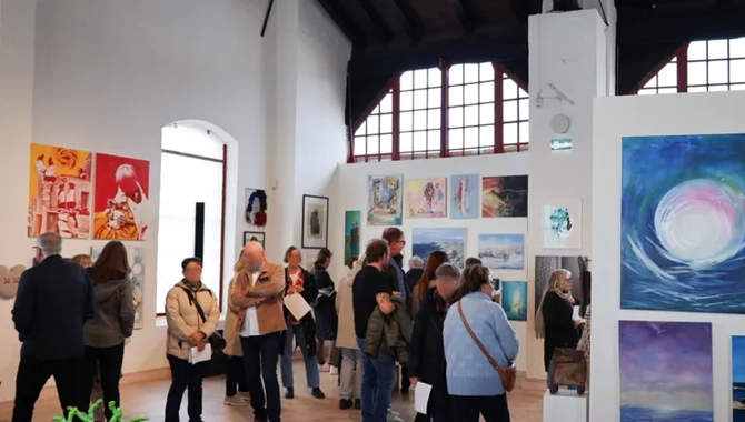 En grupp människor som tittar på utställd konst på Konsthallen Lokstallet.