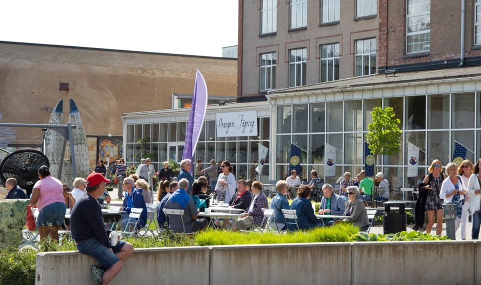 Solig bild på uteserveringen framför Rörstrands café på Rörstrand Center.