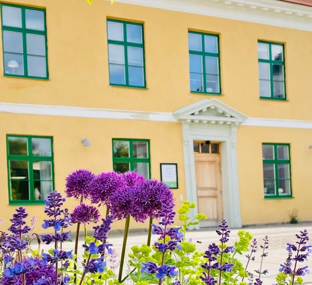 Gul byggnad med gröna fönster