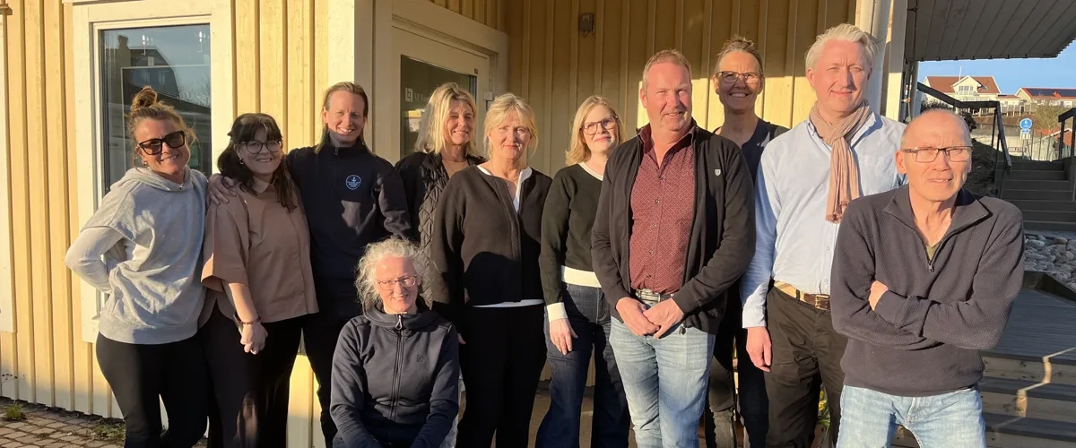 En grupp människor, styrelsen Destination Skaftö, står framför Solrosen i Krögen.