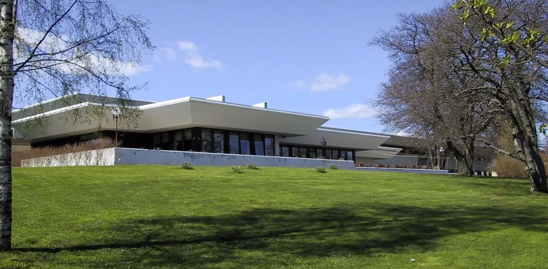 A large building sitting on top of a lush green field.
