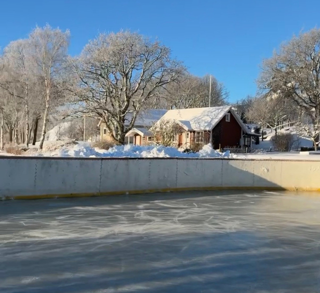 En isbana med ett hus i bakgrunden.