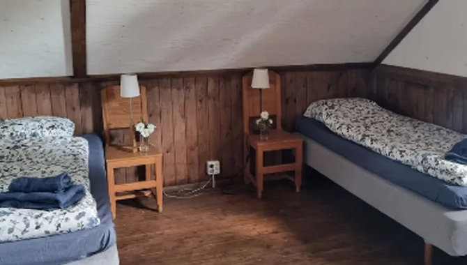 Ett rum med två sängar och en matta på golvet.