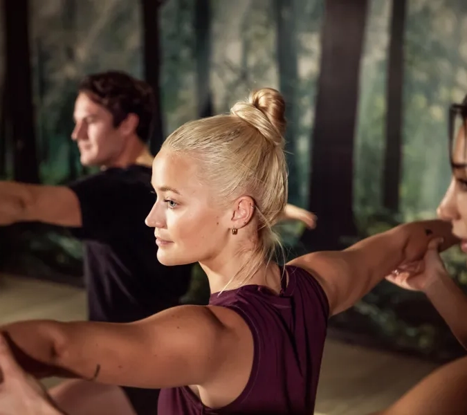 En grupp människor som gör yoga i ett rum.