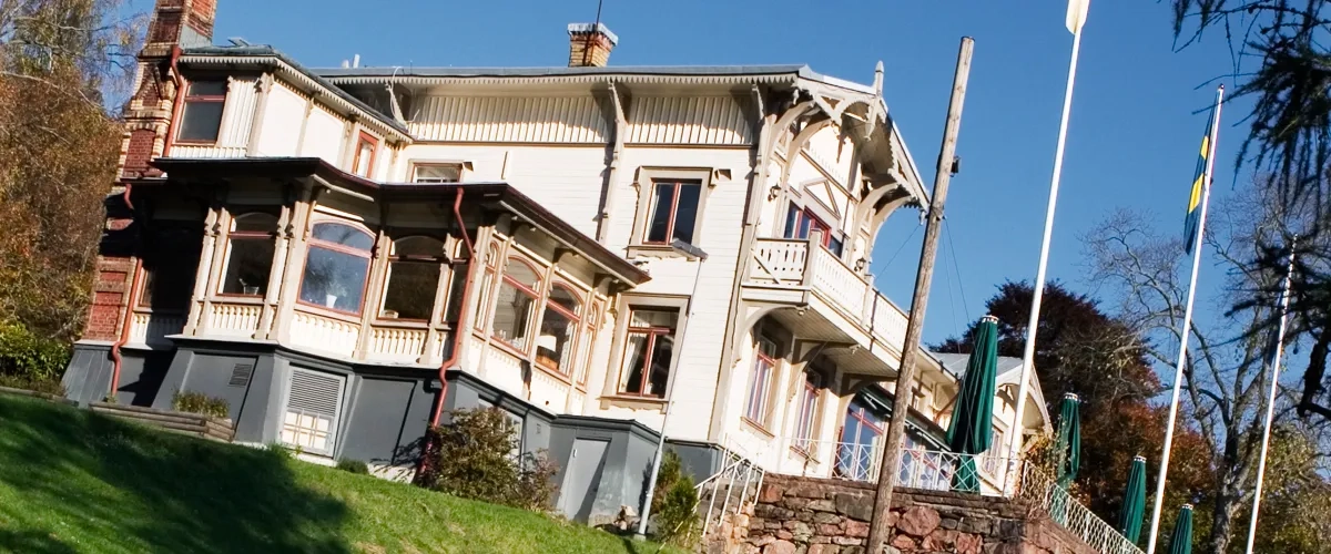 Ett stort hus som ligger på toppen av en grönskande sluttning.