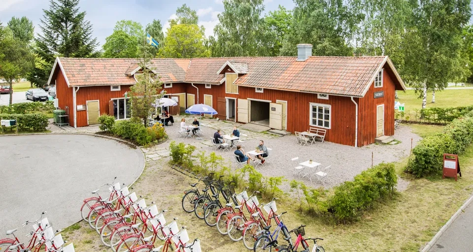 A group of bicycles parked in front of a red building.