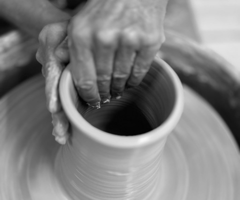En person som tillverkar en vas på en drejskiva.