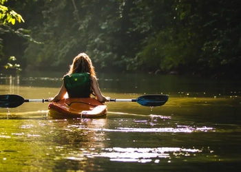 Flicka som paddlar kanot.