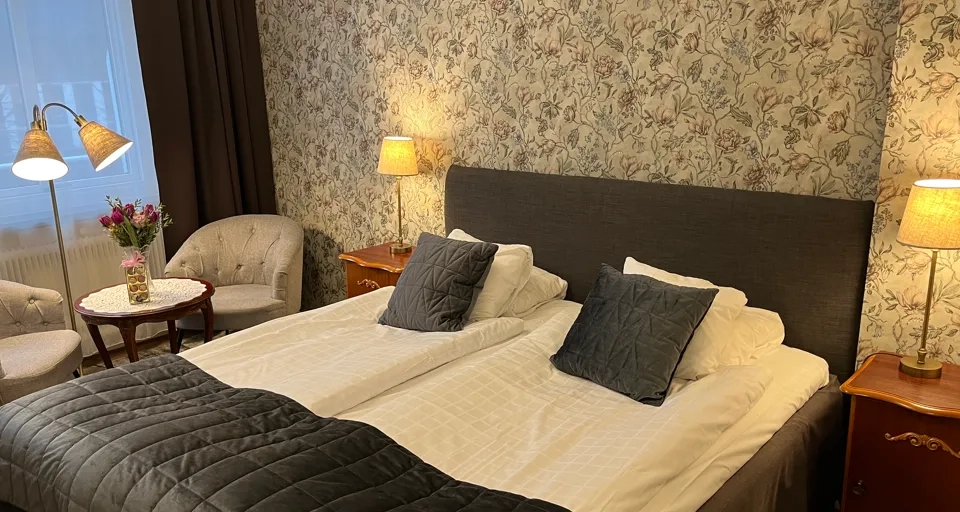 A large bed sitting in a bedroom next to a window.