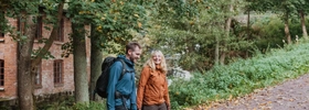 Ein Mann und eine Frau gehen einen Waldweg entlang.