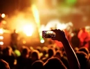 Folkhav och en person som filmar en konsert med sin mobil.