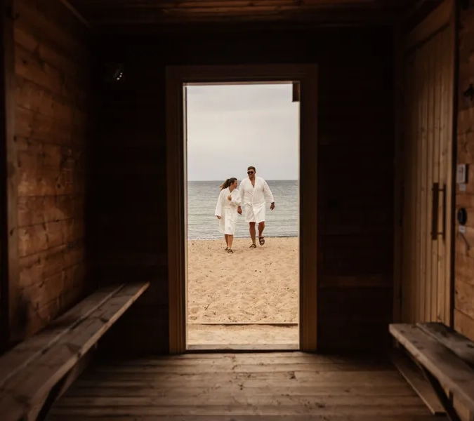 ett par har tagit ett dopp i vättern och är på väg tillbaka in i badhyttsbastun i hjo 