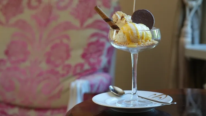 Glasskreation i förgrunden med glasskulor och kex och en fåtölj i bakgrunden.