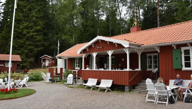 Några personer sitter utanför en röd byggnad.