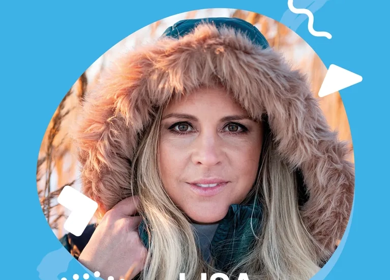 En kvinna med pälsmössa mot en blå bakgrund.