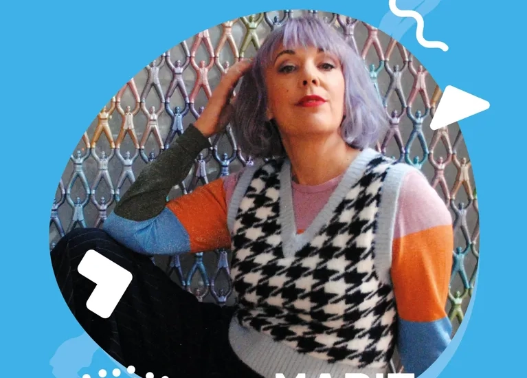 En kvinna med lila hår sitter på en stol.