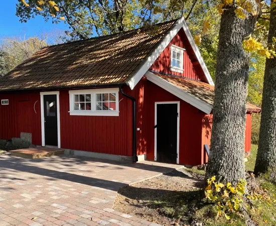 Ett litet rött hus med en tegelgång.