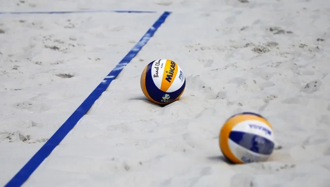 Två vollybollar på sand.
