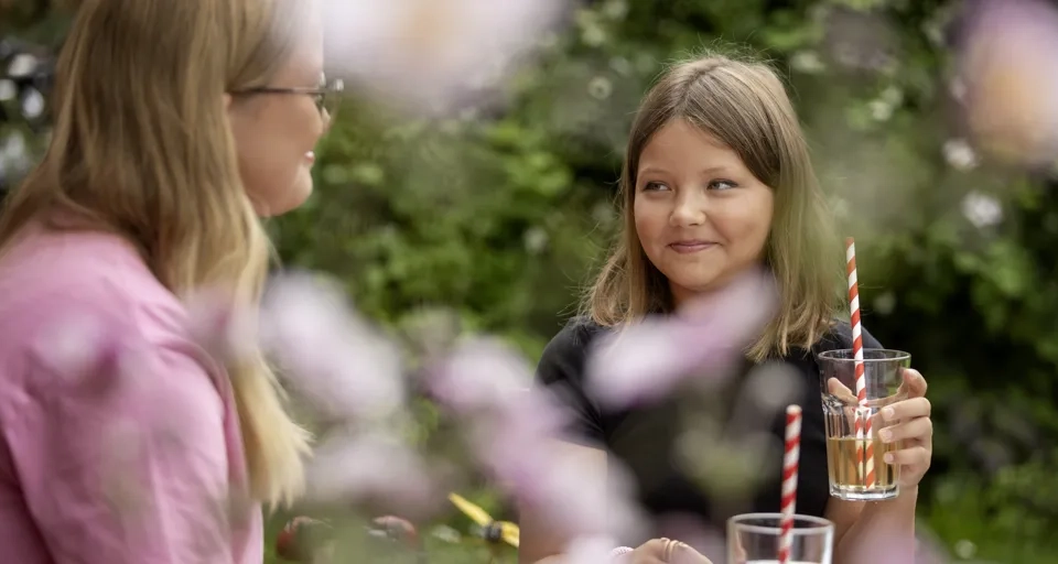 En kvinna och en liten flicka sitter vid ett bord.