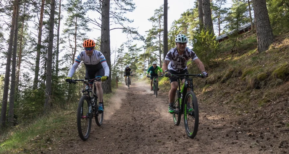 Några personer som cyklar på en grusväg.