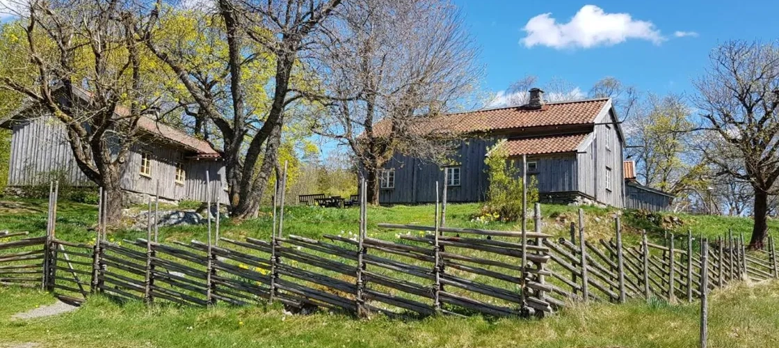 A farm with a fence and a barn in the background.